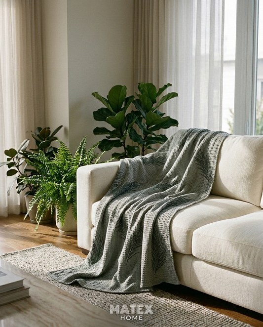 Sage Fern Pique Blanket draped on a sofa
