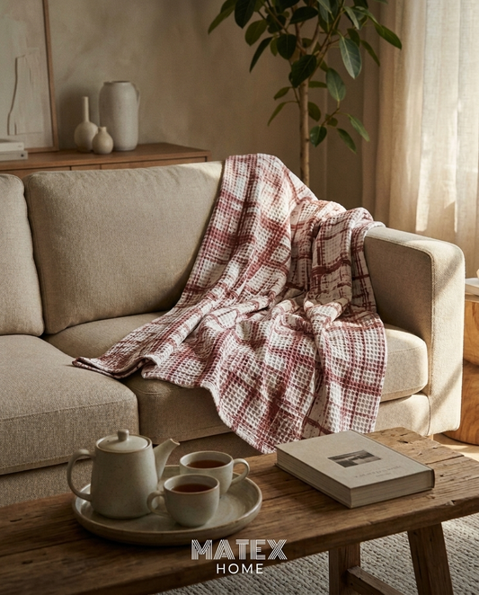 Dusty Grid Waffle Blanket draped on a sofa